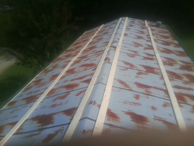 Rusted metal roof panels with new wood purlins before replacement — Storm Damage Roof Repair in Stirling by Roofing Brothers
