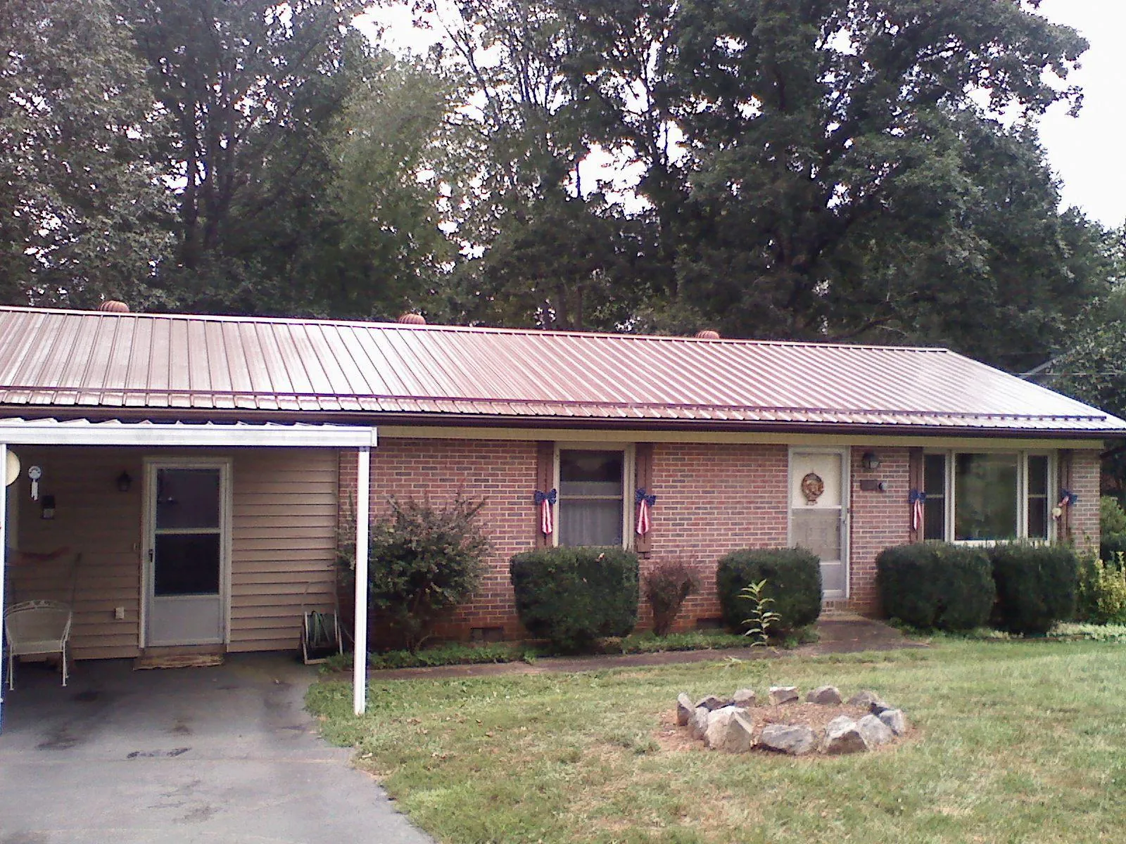 Bronze metal roof and carport on a brick ranch home — Roof Repair work by our crew in Stirling